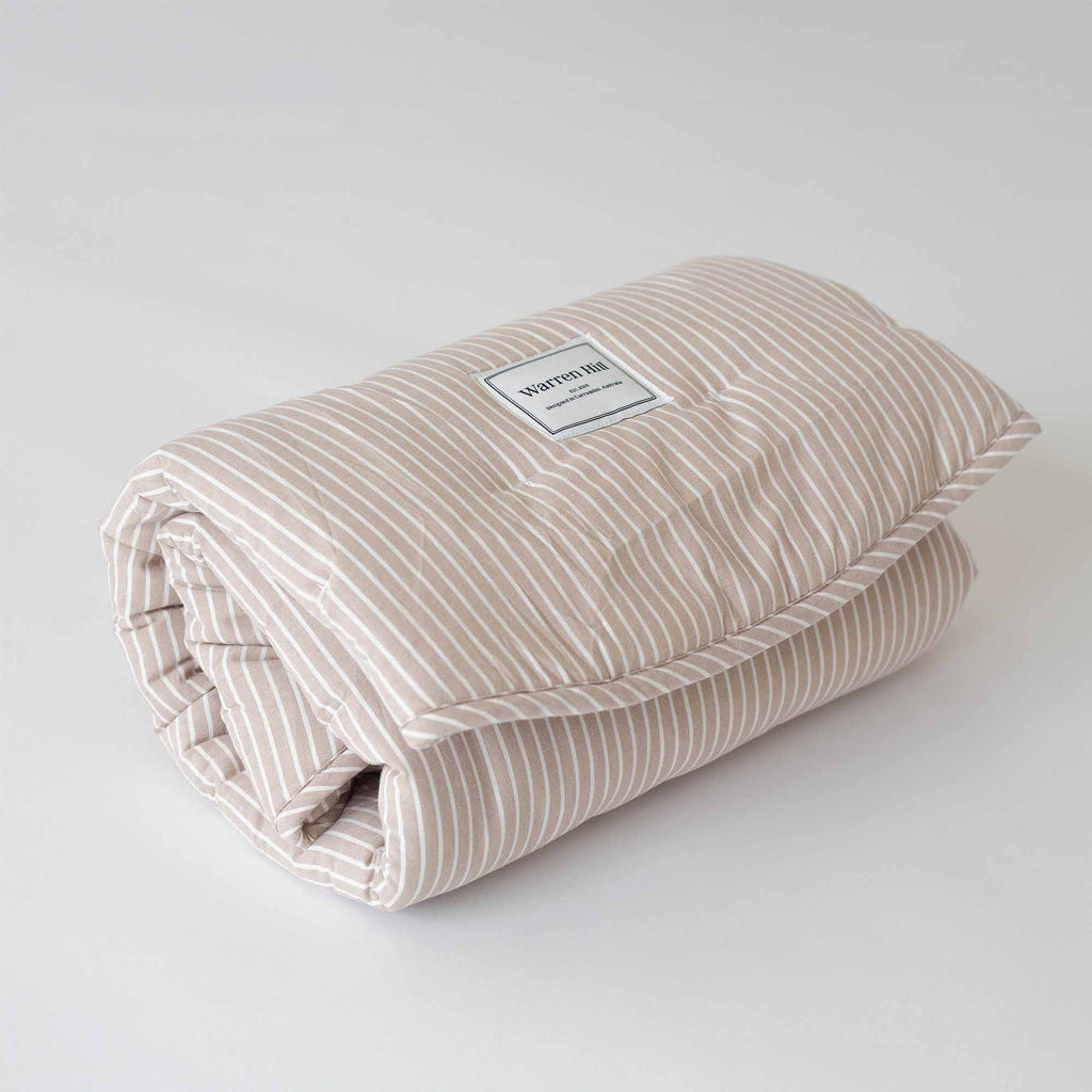 Soft and quilted Hamptons Stripe Cotton Play Mat, rolled up for storage