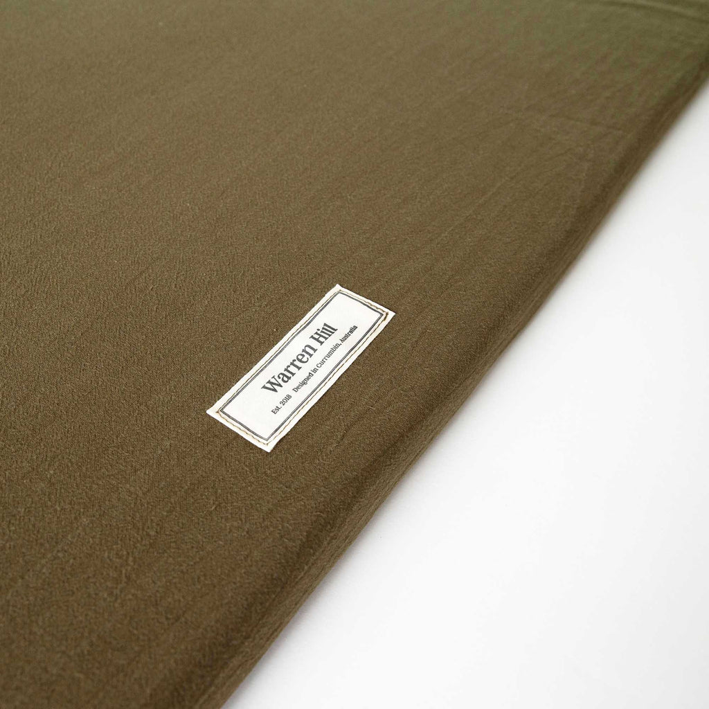 Detailed view of the Warren Hill label stitched onto the Olive Padded Play Mat.