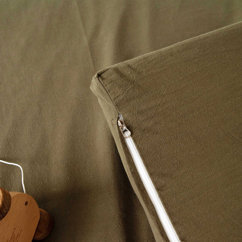 Zipper detail of the Olive Padded Play Mat, showing its removable, machine-washable cover.