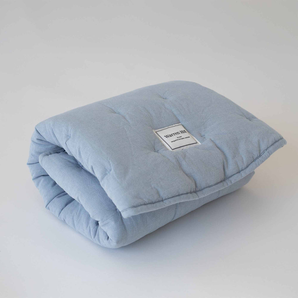 Sky Blue Cotton Quilted Play Mat neatly folded, showcasing Warren Hill's brand label.