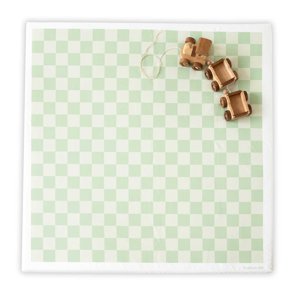 Wipeable Green Padded Play Mat by Warren Hill with a checkered design and wooden toy trucks on top.