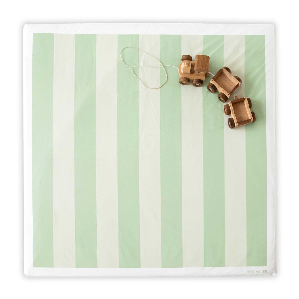 Wipeable Green Padded Play Mat featuring a reversible striped design, styled with wooden toys.