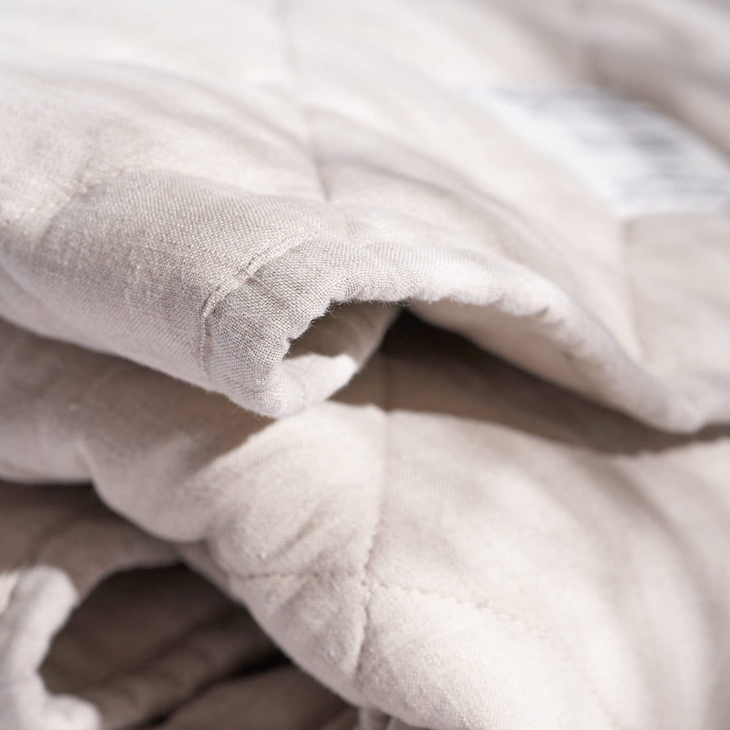 A close-up view of the Warren Hill Natural Linen Play Mat’s stitching